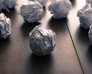 wadded up paper balls on a desk