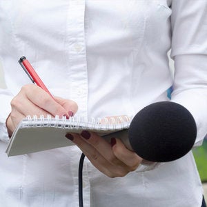 journalist with notebook and microphone