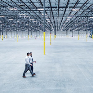 Two business men in a large empty warehouse