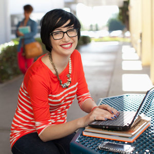 woman smiling at camera using a laptop