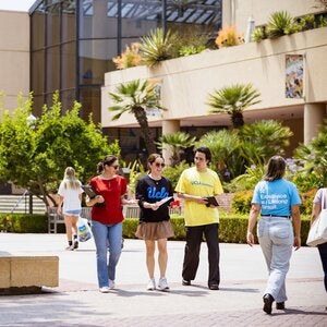 small group of students walking by The Bruin statue on the UCLA campus