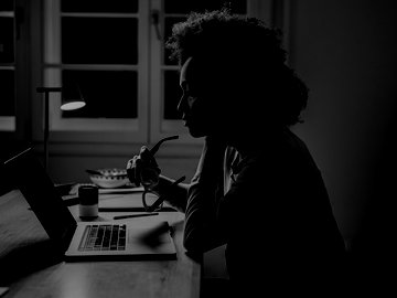 Woman holding glasses analyzing laptop screen